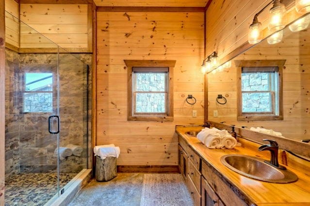 bathroom with wood-type flooring, vanity, wooden walls, and walk in shower