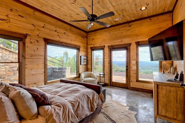 bedroom with wood ceiling, access to exterior, concrete flooring, and wooden walls