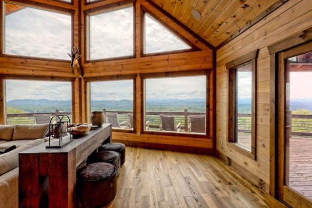 sunroom with a mountain view, wooden walls, lofted ceiling, hardwood / wood-style flooring, and wooden ceiling