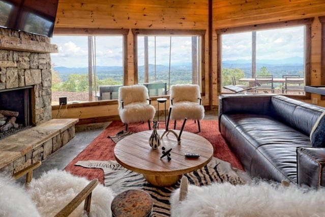 living room featuring a mountain view, a wealth of natural light, and a stone fireplace