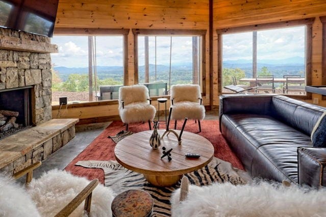 living room with a mountain view and a stone fireplace