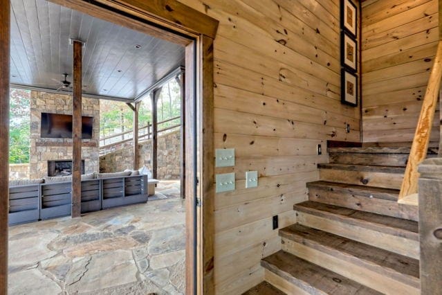 staircase featuring wood walls, wooden ceiling, and ceiling fan