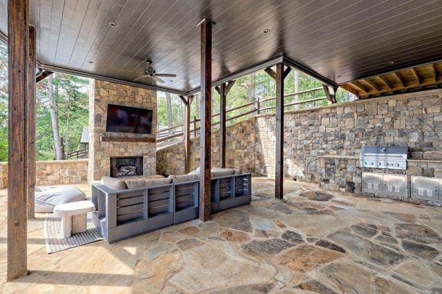 view of patio featuring area for grilling, an outdoor stone fireplace, and ceiling fan