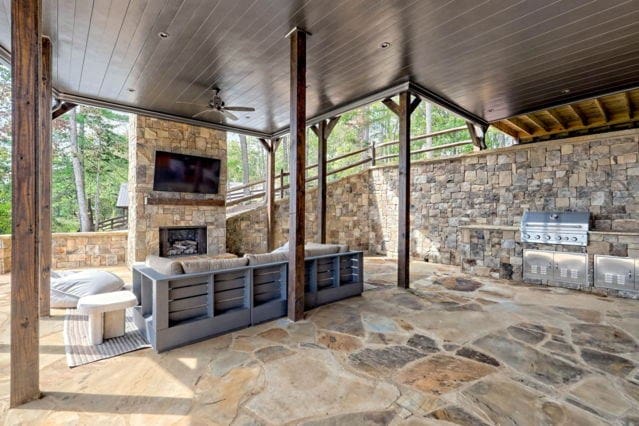 view of patio featuring area for grilling, ceiling fan, an outdoor living space with a fireplace, and a grill
