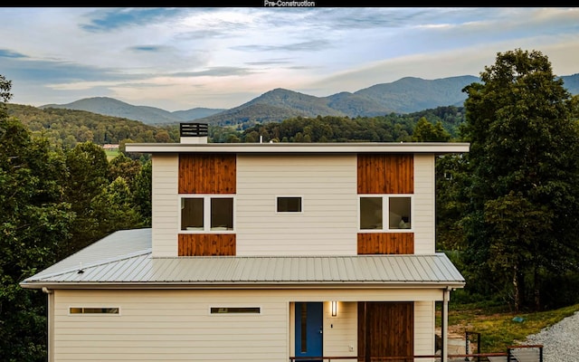 view of front of property with a mountain view and a balcony