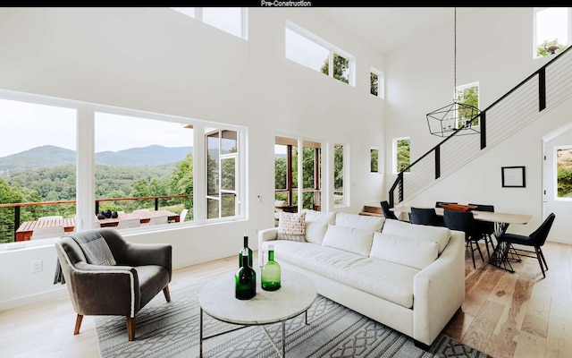 living room featuring a mountain view, a healthy amount of sunlight, and light hardwood / wood-style flooring