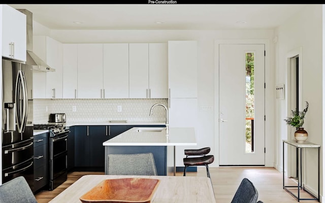 kitchen featuring stainless steel fridge with ice dispenser, gas stove, light hardwood / wood-style floors, and a wealth of natural light