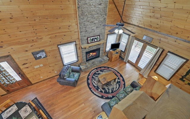 166 Dallas Ln, Blue Ridge, GA 30513 - living room featuring a stone fireplace, wood walls, wood finished floors, and a wealth of natural light