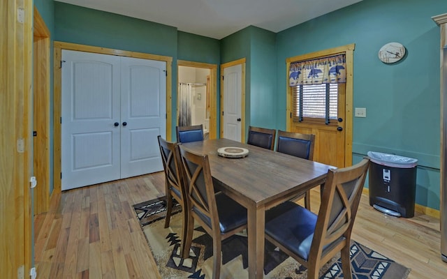 dining room with light wood-type flooring and baseboards