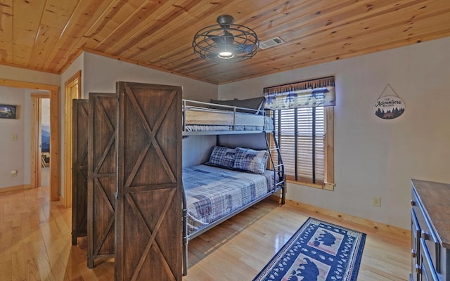 bedroom with hardwood / wood-style floors, wooden ceiling, baseboards, and visible vents