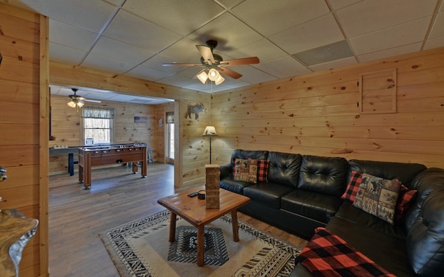 living room featuring a ceiling fan, wood finished floors, and a paneled ceiling