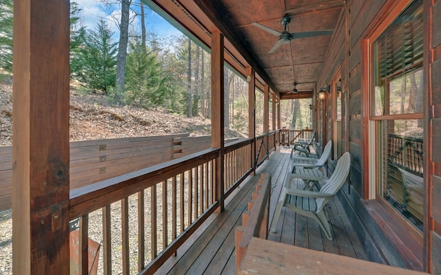 wooden terrace with covered porch and a ceiling fan