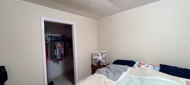 carpeted bedroom featuring a textured ceiling and a closet