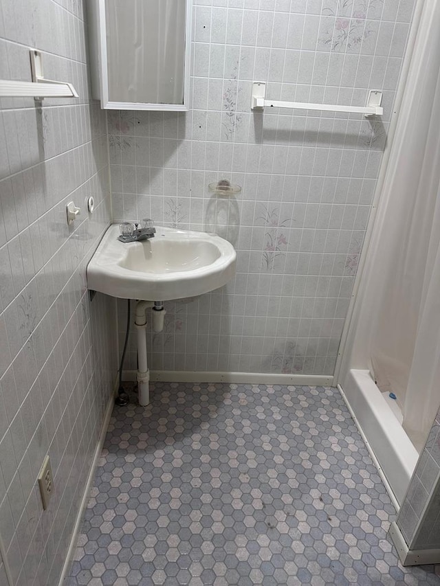 bathroom with tile patterned floors, tile walls, and walk in shower