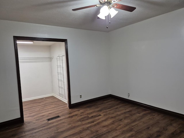 unfurnished bedroom with ceiling fan, dark hardwood / wood-style flooring, a closet, and a textured ceiling