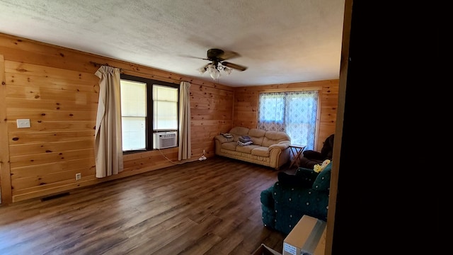 miscellaneous room with dark wood-type flooring, ceiling fan, cooling unit, a textured ceiling, and wood walls