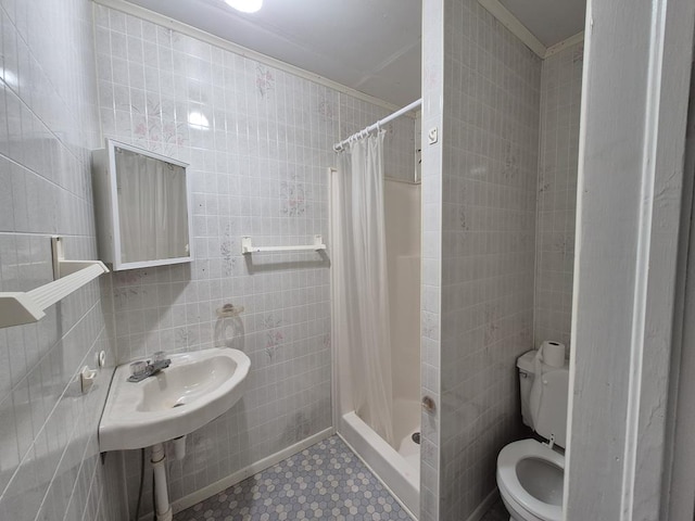 bathroom with toilet, curtained shower, and tile walls