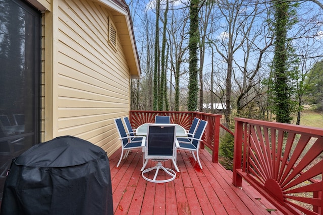 deck with outdoor dining space and area for grilling