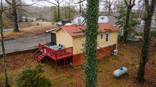 rear view of property with metal roof, stairs, fence, a wooden deck, and central air condition unit