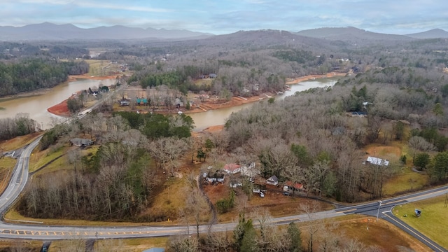 birds eye view of property featuring a forest view and a water and mountain view