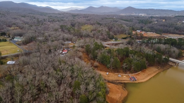 drone / aerial view featuring a water and mountain view and a wooded view