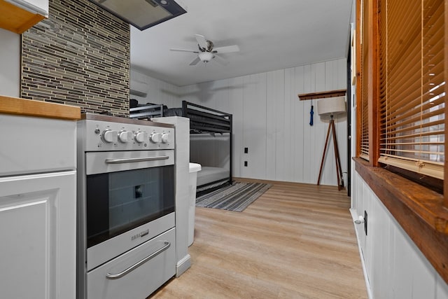 kitchen with ceiling fan, light wood-type flooring, and wall oven