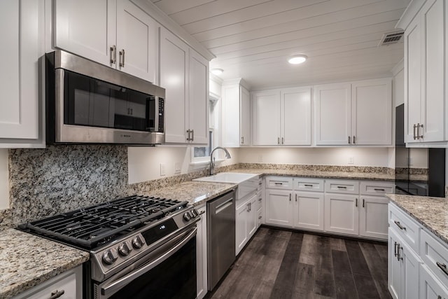 kitchen featuring dark wood-style floors, appliances with stainless steel finishes, a sink, and white cabinets