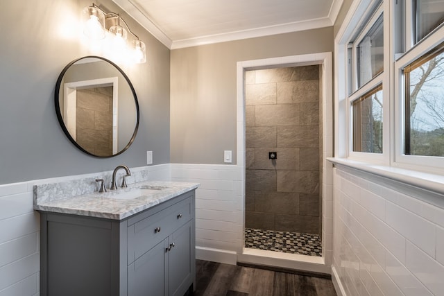 full bathroom featuring wainscoting, crown molding, tile walls, and wood finished floors