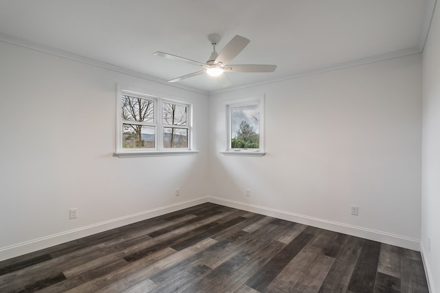 spare room with dark wood-type flooring, ornamental molding, baseboards, and a ceiling fan