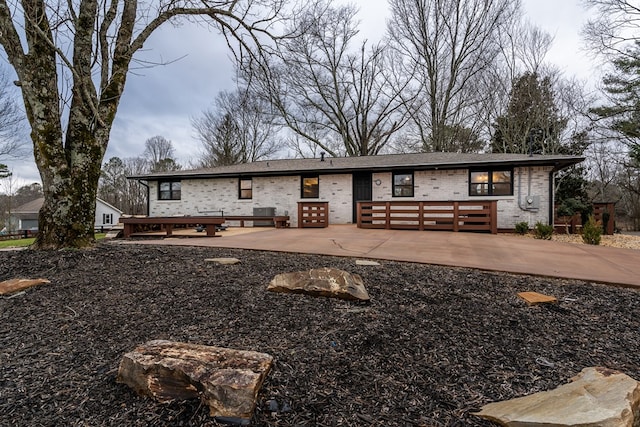 view of front of house featuring a patio area and brick siding