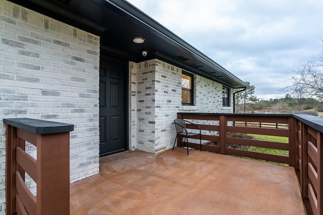 exterior space featuring brick siding and a balcony