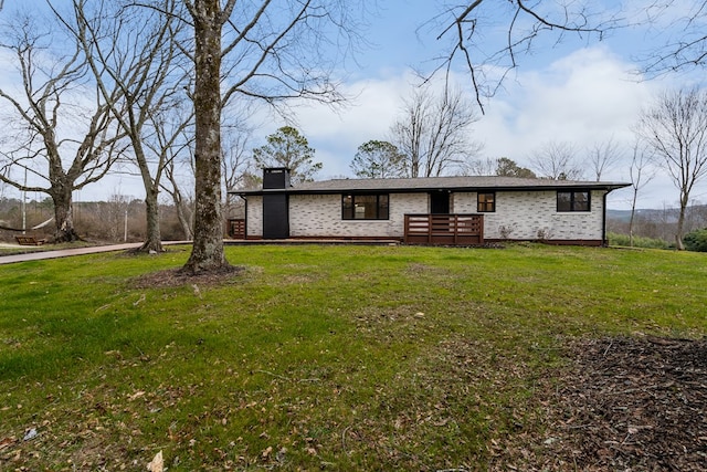 mid-century modern home with a chimney and a front yard