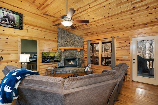 living room with wood ceiling, high vaulted ceiling, a fireplace, wood-type flooring, and wood walls