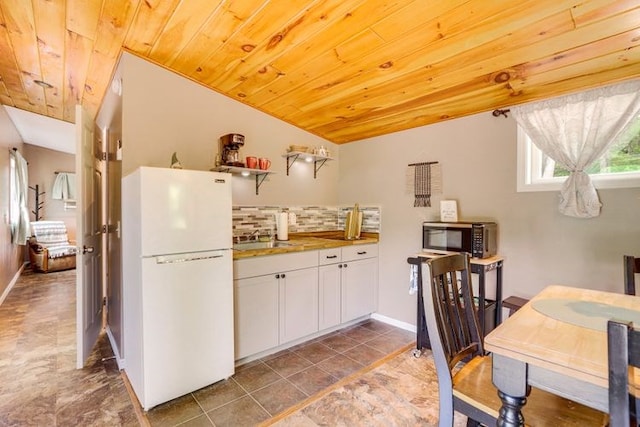 kitchen featuring decorative backsplash, wooden ceiling, white cabinets, white fridge, and lofted ceiling