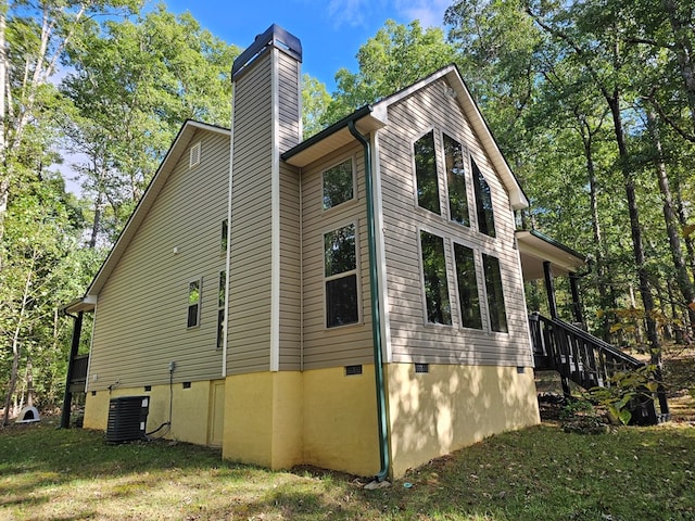 view of side of home featuring a yard and central air condition unit