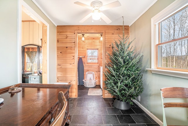 interior space with ceiling fan, ornamental molding, and wooden walls