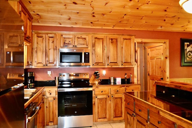 115 Black Oak Ridge Rd, Blue Ridge, GA 30513 - kitchen featuring appliances with stainless steel finishes, brown cabinetry, light tile patterned floors, tile counters, and wooden ceiling