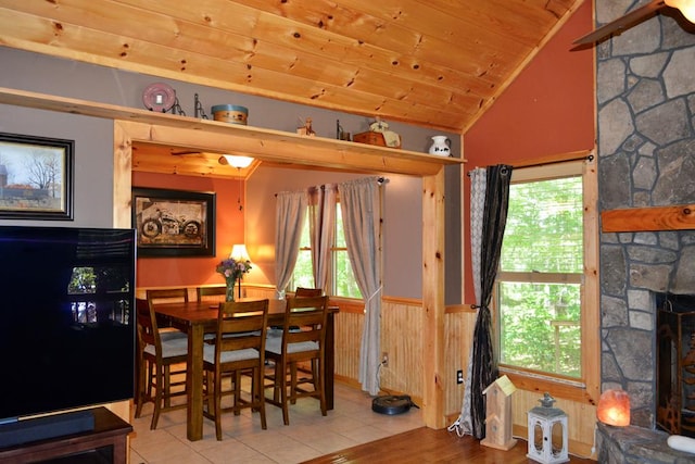 115 Black Oak Ridge Rd, Blue Ridge, GA 30513 - dining space featuring lofted ceiling, a stone fireplace, a wainscoted wall, wooden ceiling, and plenty of natural light