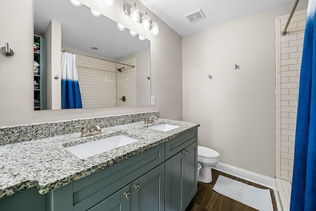 full bathroom featuring a sink, toilet, wood finished floors, and visible vents