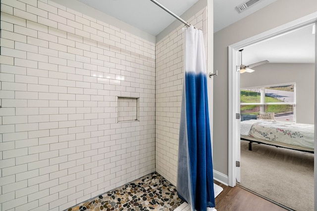 bathroom with visible vents, ensuite bathroom, tiled shower, a ceiling fan, and vaulted ceiling