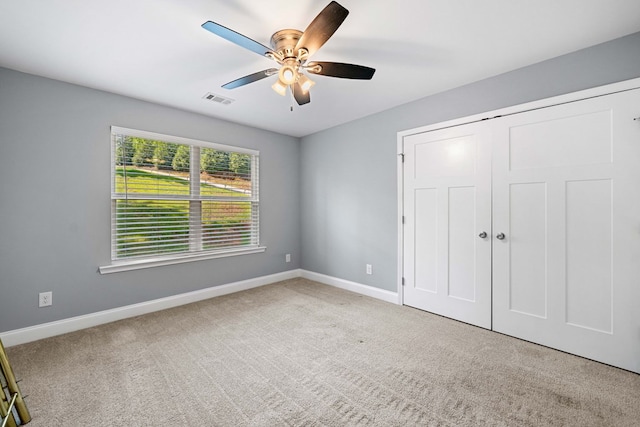 unfurnished bedroom with carpet floors, baseboards, visible vents, and a closet