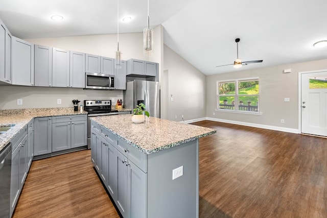 kitchen with ceiling fan, appliances with stainless steel finishes, open floor plan, dark wood-type flooring, and gray cabinetry