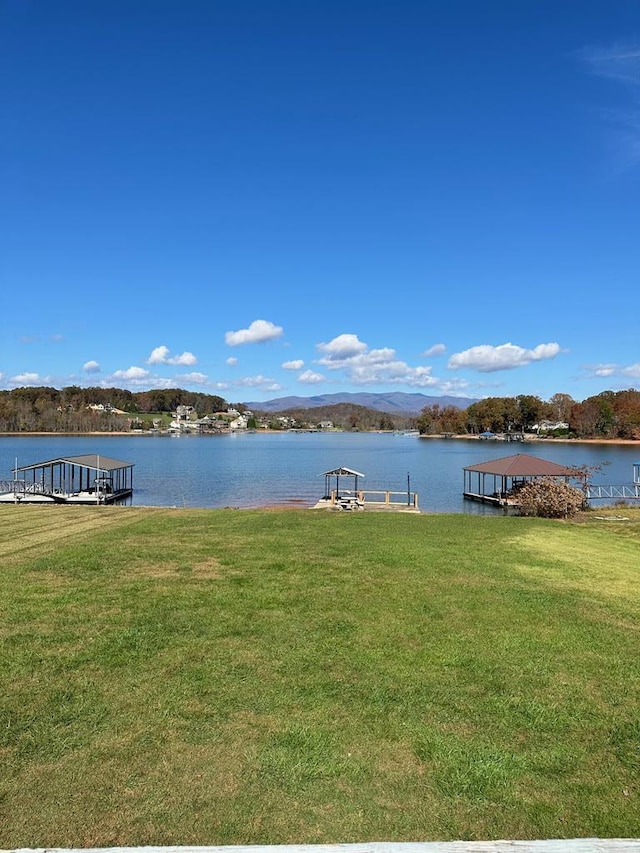 dock area featuring a yard and a water and mountain view