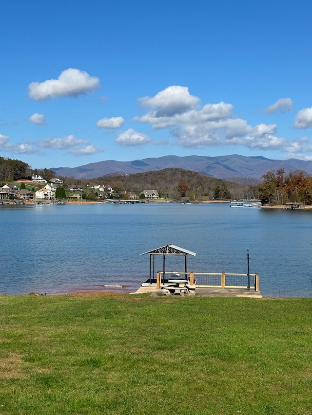 dock area featuring a lawn and a water and mountain view