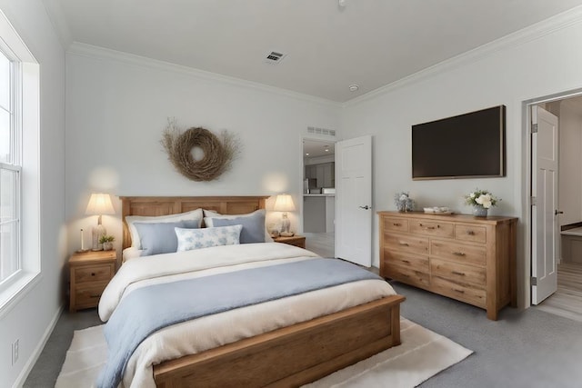 bedroom with carpet, ensuite bathroom, and crown molding