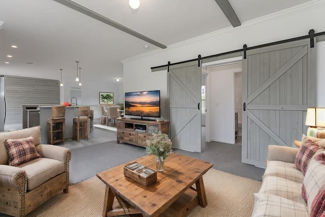 living room with beamed ceiling, a barn door, crown molding, and sink