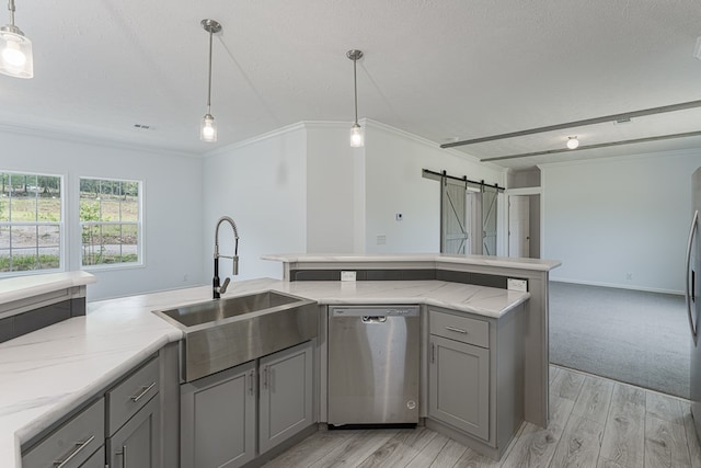 kitchen with dishwasher, a barn door, sink, and decorative light fixtures