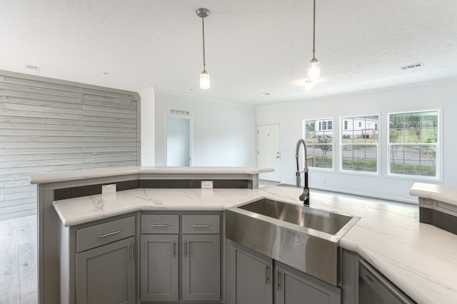 kitchen with a textured ceiling, sink, pendant lighting, dishwasher, and gray cabinets