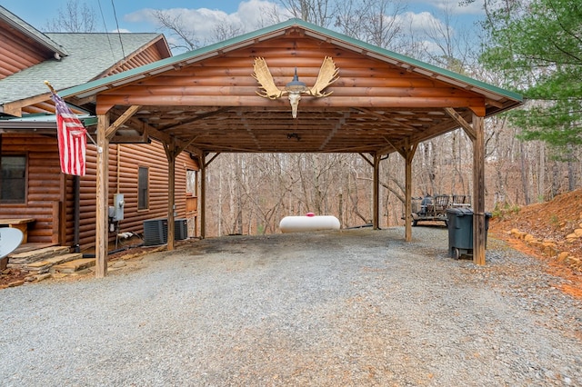 view of car parking with a detached carport and gravel driveway