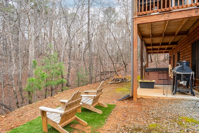 view of yard with a patio area, a hot tub, and a wooded view